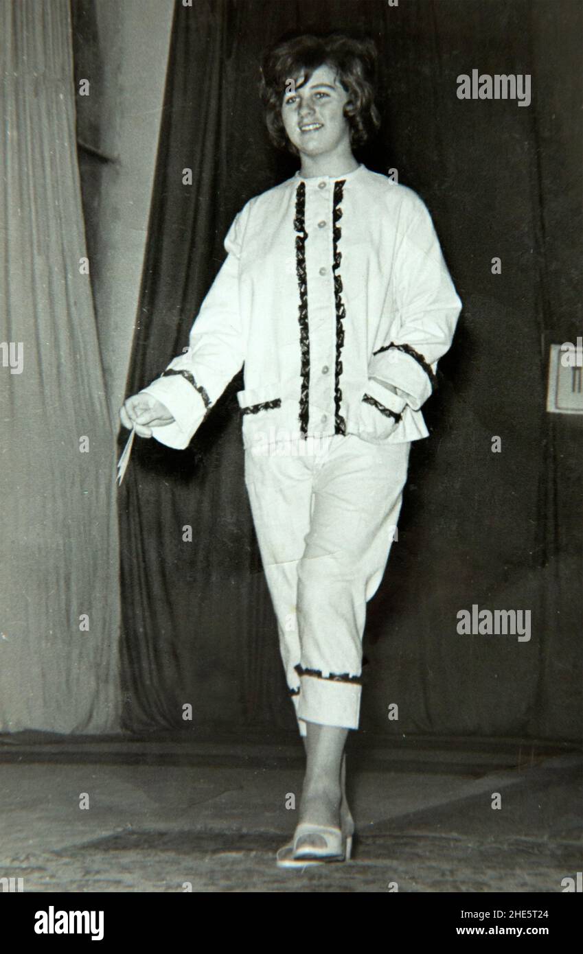 Mannequin marchant sur une rampe de plate-forme lors d'un défilé de mode en intérieur en 1960s, Bulgarie, Europe de l'est Banque D'Images