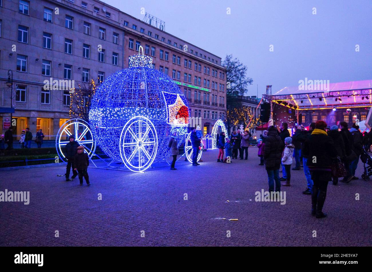 Vue de nombreuses personnes sur la place avec chariot de Noël et lampes la nuit. Banque D'Images