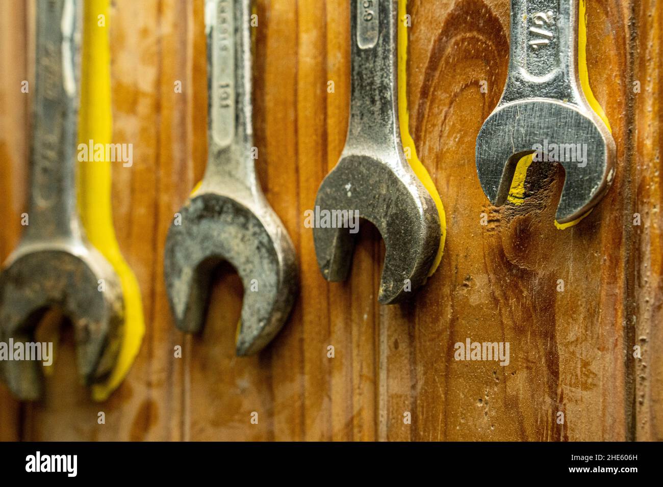 Gros plan de vieilles clés de différentes tailles rouillées accrochées à un mur en bois Banque D'Images