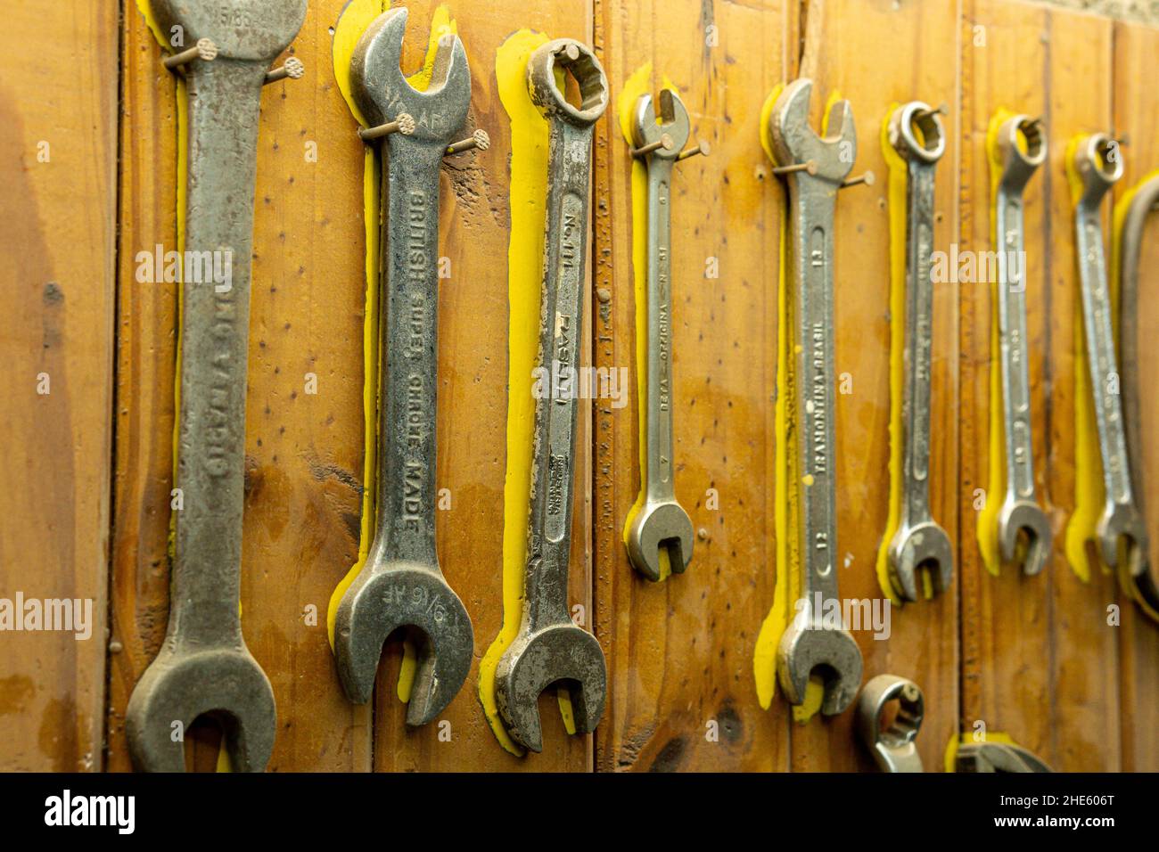 Gros plan de vieilles clés de différentes tailles rouillées accrochées à un mur en bois Banque D'Images