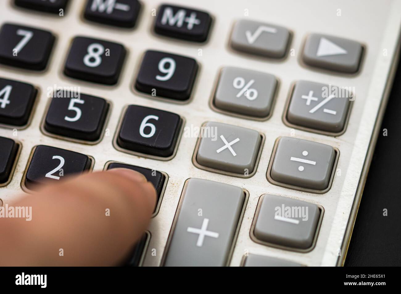 Appuyer avec le doigt sur le bouton calculatrice. Concept fiscal, concept comptable. Homme méconnaissable mains tenant et utilisant une calculatrice Banque D'Images