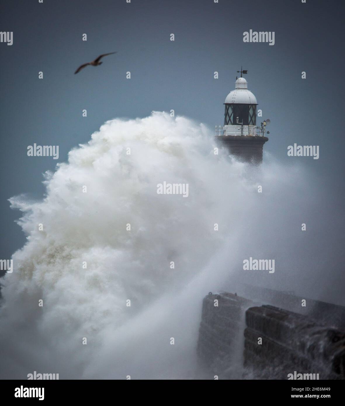 Des vagues géantes battent le phare et la jetée nord qui gardent l'embouchure du Tyne à Tynemouth, en Angleterre Banque D'Images