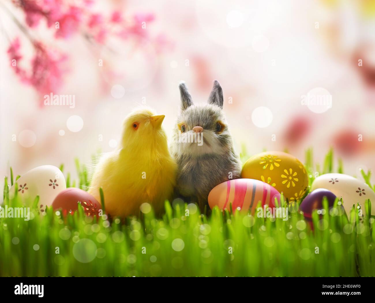 Mignonne petite poussette de pâques sur un pré vert dans la nature avec paysage de fleurs au printemps et lapin de pâques avec oeufs de pâques.Concept de Pâques. Banque D'Images