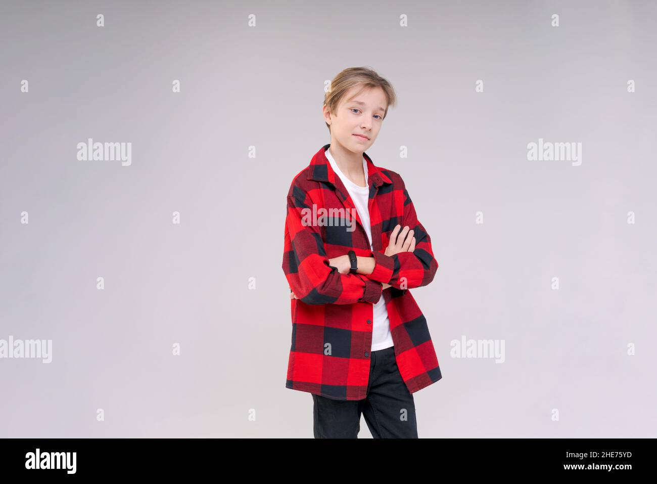 Gros plan d'un jeune homme sérieux et concentré qui regarde un portrait de studio d'appareil photo isolé sur un fond gris et blanc de studio.Un homme millénaire réfléchi pose pour un album photo. Banque D'Images