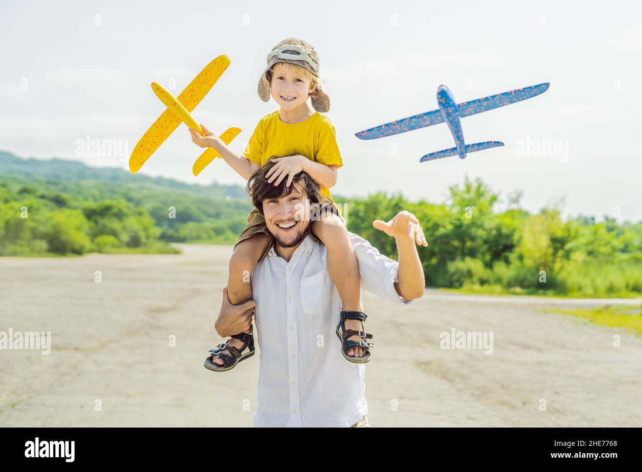 Happy father and son Playing with toy airplane contre l'ancienne piste d'arrière-plan. Concept de voyager avec des enfants Banque D'Images