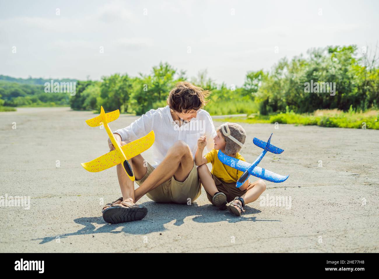 Happy father and son Playing with toy airplane contre l'ancienne piste d'arrière-plan. Concept de voyager avec des enfants Banque D'Images