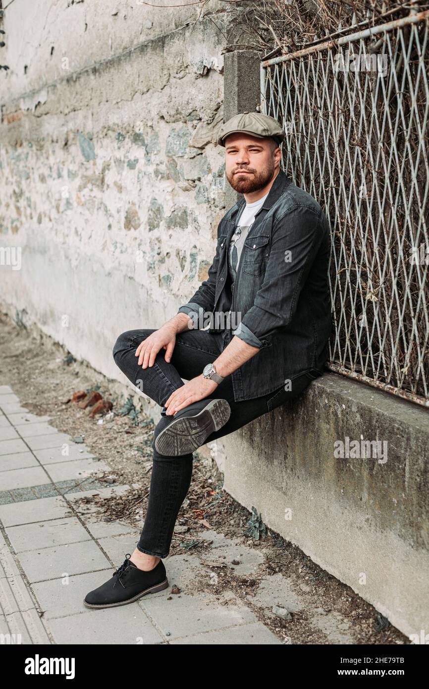 Portrait d'un beau gars avec un chapeau de lierre appuyé sur le mur Banque D'Images