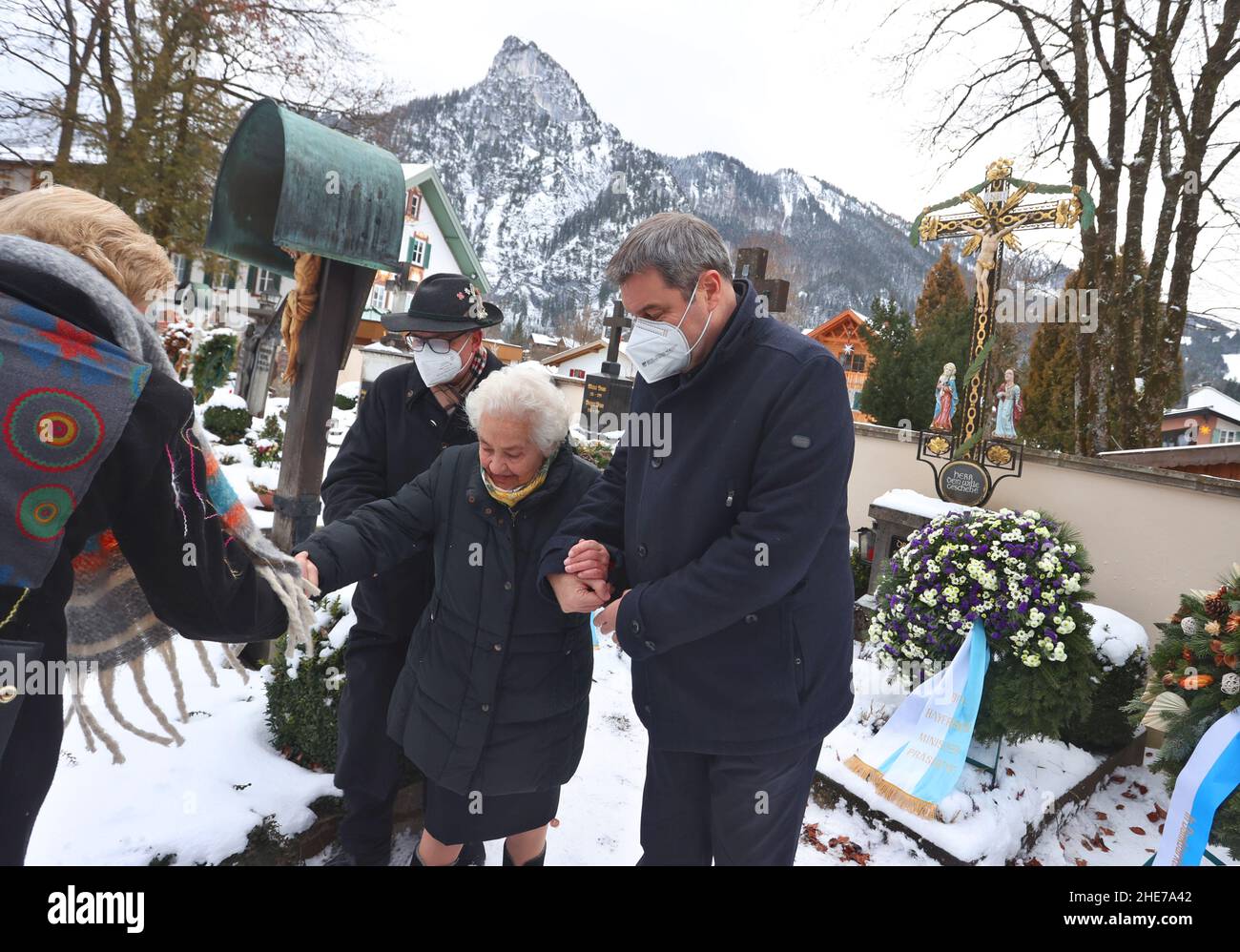 Oberammergau, Allemagne.09th janvier 2022.Markus Söder, ministre-président bavarois (CSU, r), soutient la veuve de Max Streibl, Irmingard Streibl, près de son fils Florian Streibl, après une cérémonie de commémoration de l'anniversaire 90th de l'ancien ministre-président bavarois, Max Streibl, au cimetière local.Credit: Karl-Josef Hildenbrand/dpa/Alay Live News Banque D'Images