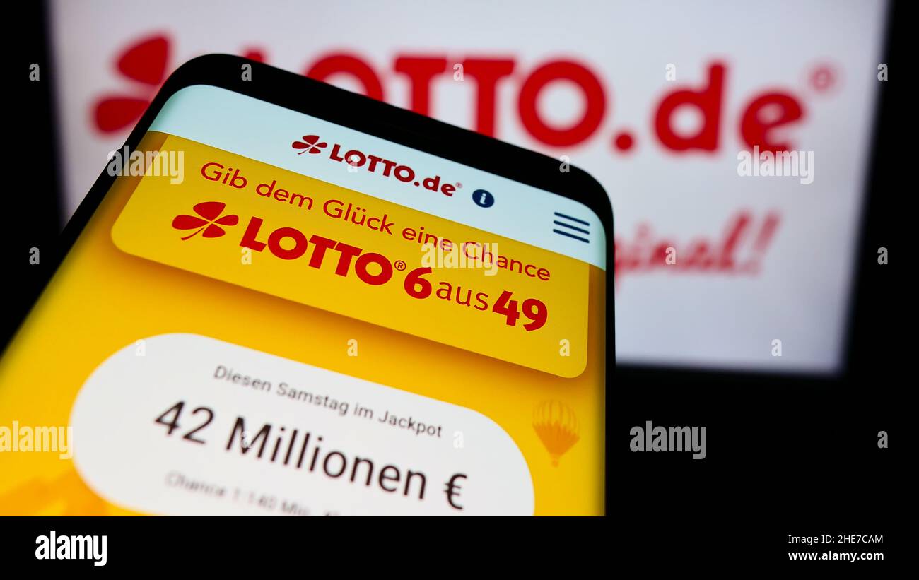 Téléphone mobile avec page web de la loterie allemande Deutsche Lotto- und  Totoblock à l'écran devant le logo d'entreprise.Faites la mise au point  dans le coin supérieur gauche de l'écran du téléphone