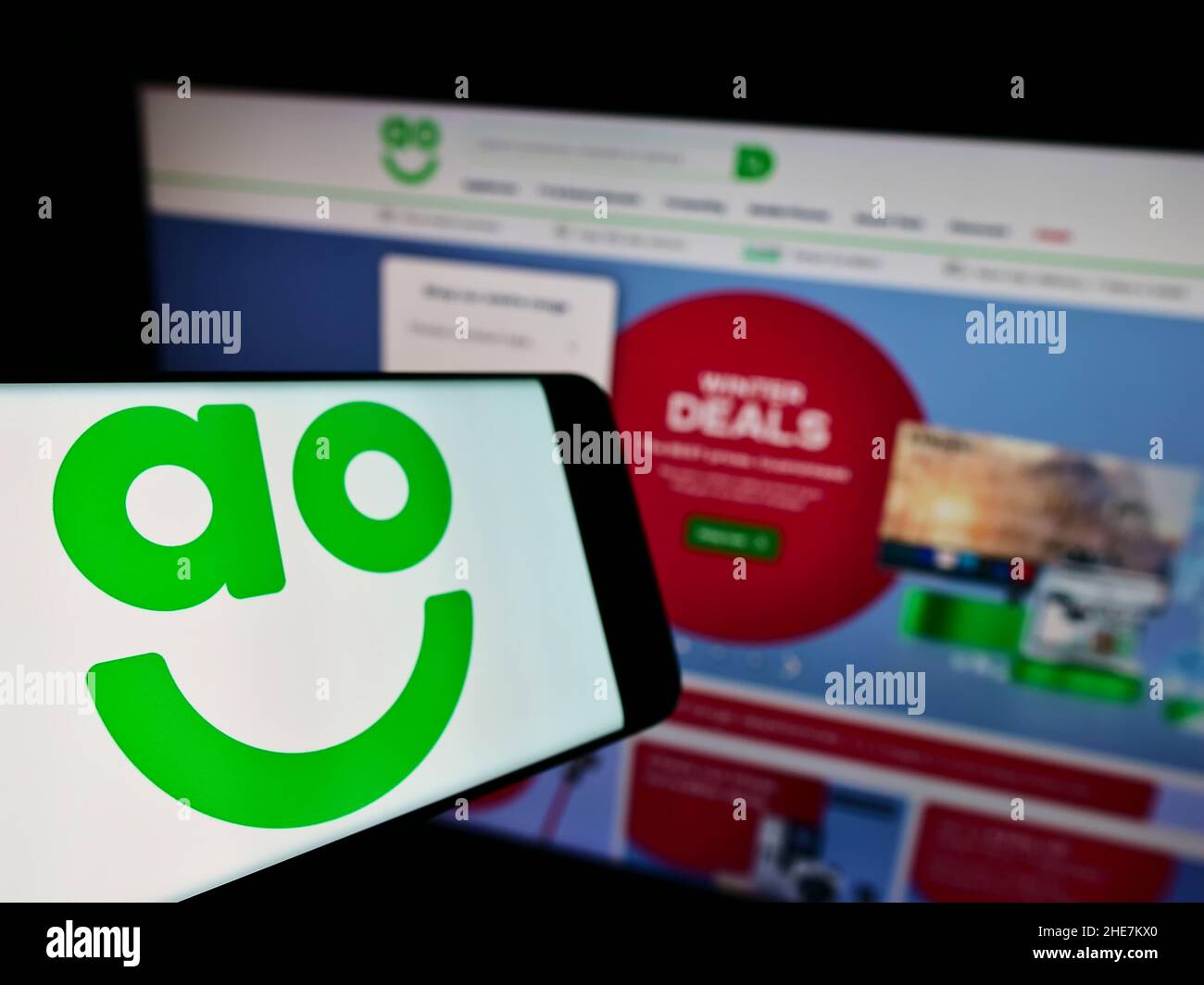 Téléphone mobile avec logo de la société britannique de vente en ligne AO World plc à l'écran devant le site Web des entreprises.Mise au point à gauche de l'écran du téléphone. Banque D'Images Téléphone mobile avec logo de la société britannique de vente en ligne AO World plc à l'écran devant le site Web des entreprises.Mise au point à gauche de l'écran du téléphone. Banque D'Images
