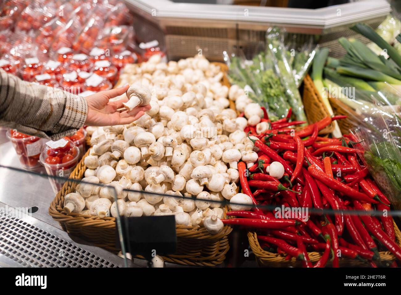 La femme choisit des champagnes dans la section des légumes du supermarché.Fille prenant des champignons de la boîte Banque D'Images