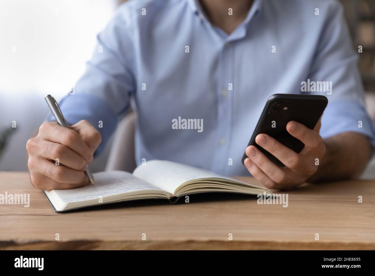 Homme d'affaires court tenant un smartphone, écrivant des informations Banque D'Images