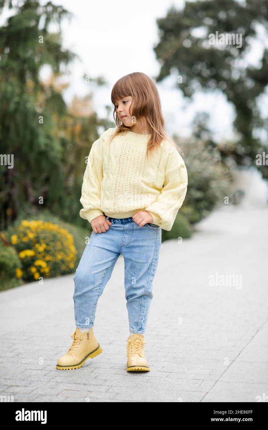 Chic enfant fille 5-6 ans vêtements tendance décontracté chandail et Jean  pantalon marche dans le parc à l'extérieur.Printemps.Petit enfant sur la  nature printemps Backgro Photo Stock - Alamy