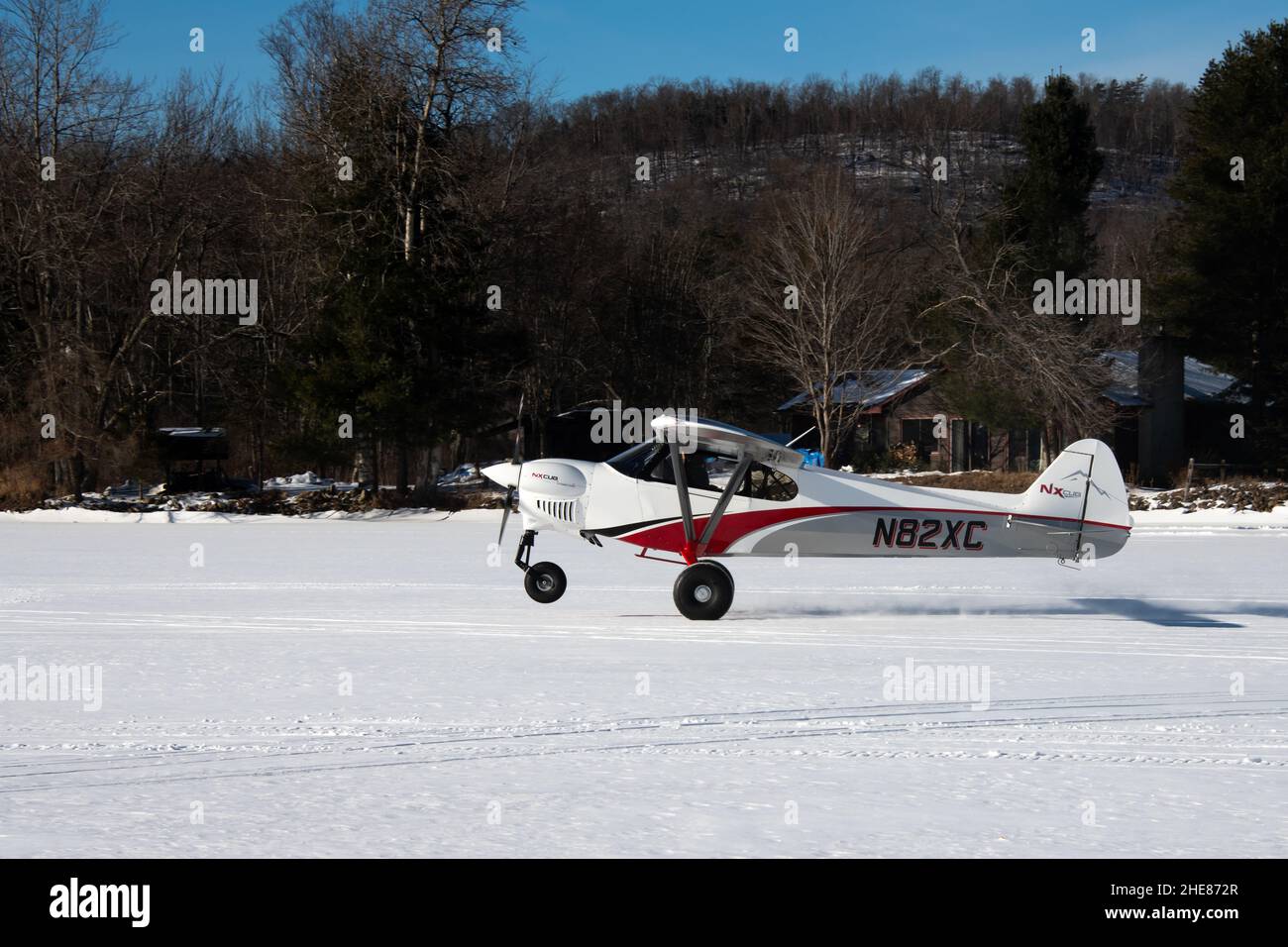 Un avion à moteur unique Cub Crafters, N82XC ans, décollant de la neige et de la glace sur le lac Pleasant dans les montagnes Adirondack, NY USA Banque D'Images