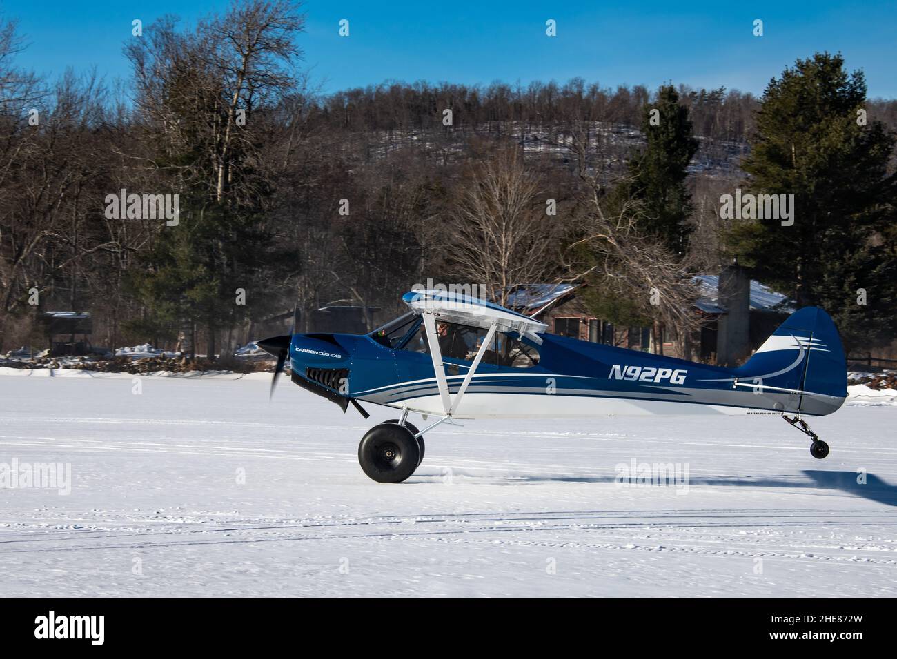 Un avion à moteur unique Cub Crafters, N92PG ans, décollant de la neige et de la glace sur le lac Pleasant dans les montagnes Adirondack, NY USA Banque D'Images