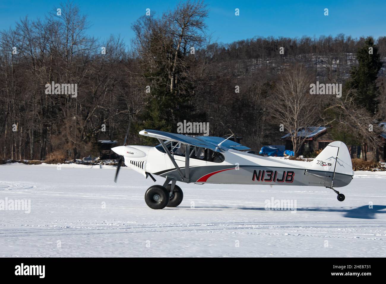 Un avion à moteur unique Cub Crafters, N131JB ans, décollant de la neige et de la glace sur le lac Pleasant dans les montagnes Adirondack, NY USA Banque D'Images