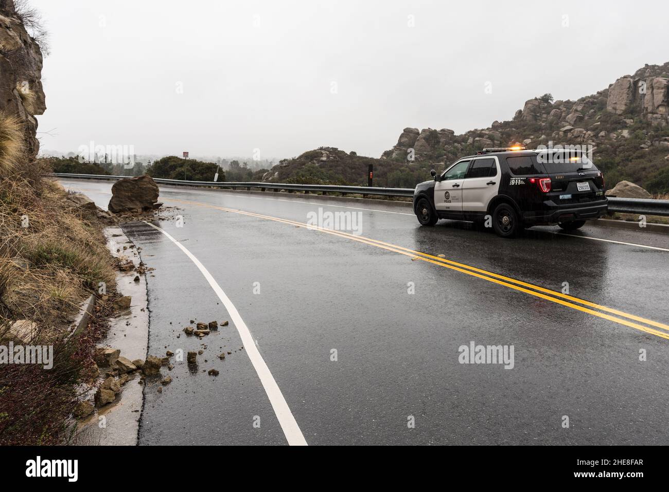 Los Angeles, Californie, États-Unis - 30 décembre 2021 : voiture de police de Los Angeles observant une petite pluie trempée glissement de terrain sur Santa Susana Pass Road. Banque D'Images