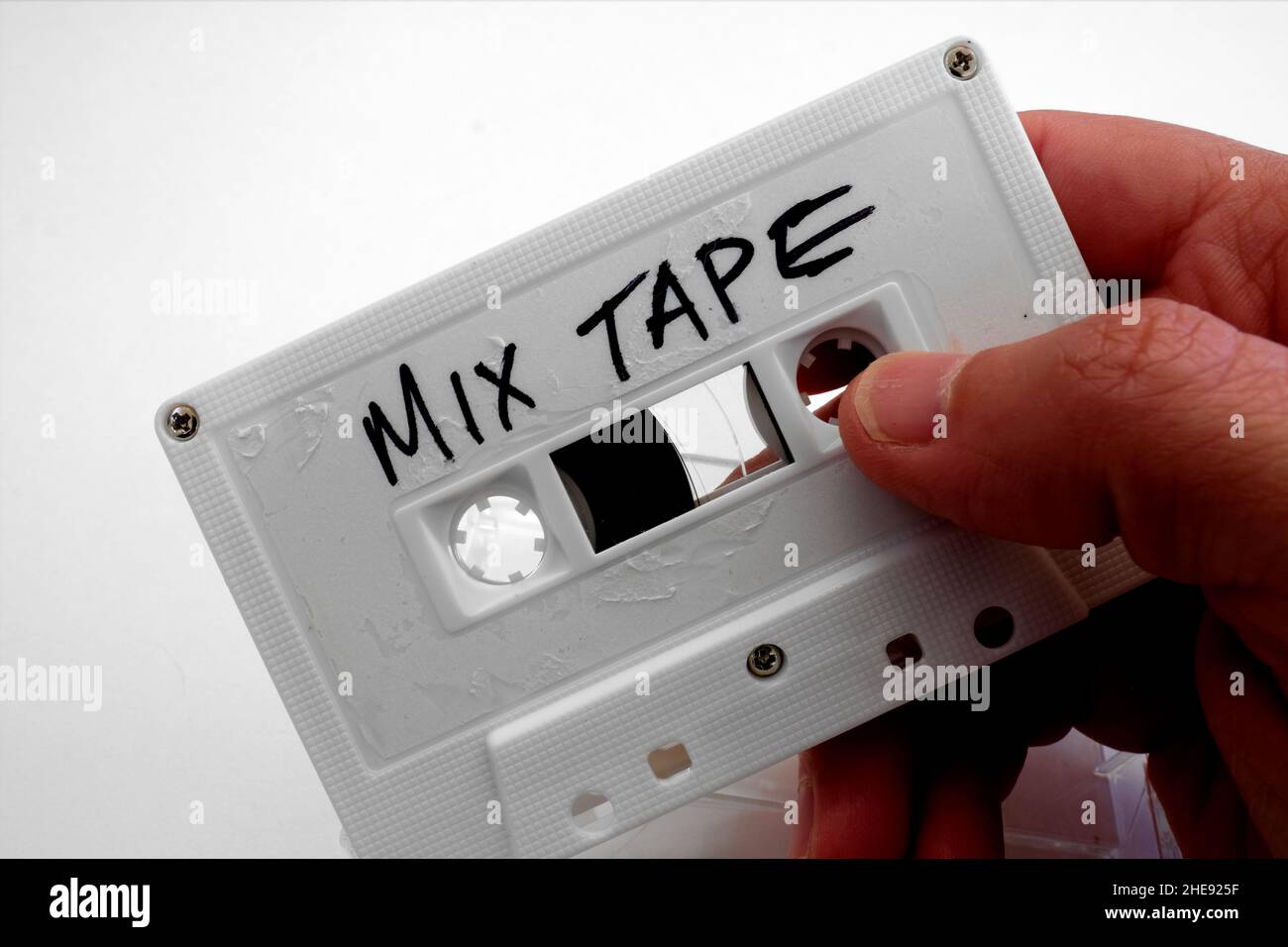 Main de l'homme tenant une cassette blanche avec les mots BANDE DE MÉLANGE écrit en main des lettres de script; compilation personnelle enregistrée de différentes chansons. Banque D'Images