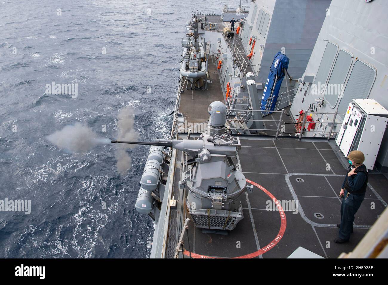 220107-N-TR141-0900 MER DES PHILIPPINES (JANV7, 2022) le compagnon 2nd de Gunner classe Joseph Brady, affecté au destroyer de missile guidé de classe Arleigh Burke USS Dewey (DDG 105), se tient pendant qu’une mitrailleuse Mark 38 – 25 mm se met à feu pendant un exercice d’entraînement au feu en direct.Dewey est affecté au Destroyer Squadron (DESRON) 15 et est en train de soutenir une Indo-Pacifique libre et ouverte.CTF 71/DESRON 15 est la plus importante force de surface déployée par la Marine et la principale force de surface de la flotte américaine 7th.(É.-U.Photo de la marine par le spécialiste des communications de masse 1st classe Benjamin A. Lewis) Banque D'Images