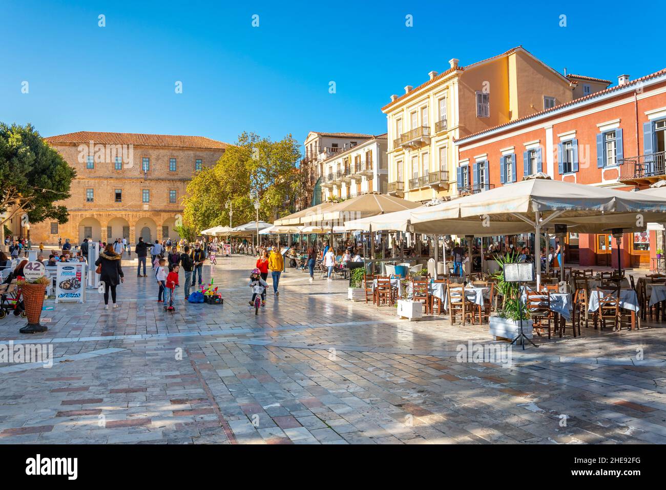 Les Grecs et les touristes profitent d'une journée d'automne ensoleillée sur la place Syntagma, dans la vieille ville historique de Nauplie, en Grèce. Banque D'Images
