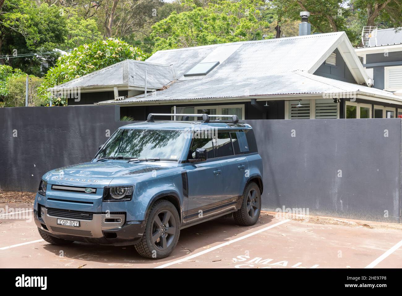 Nouveau véhicule tout-terrain Land Rover Defender 110 quatre portes en bleu Tasman, garé à côté d'une plage de Sydney, Nouvelle-Galles du Sud, Australie Banque D'Images