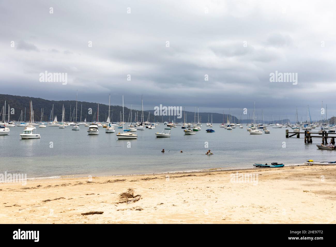 Les nuages de tempête d'été de Sydney se rassemblent au-dessus de Clareville Beach et de Pittwater, avec des bateaux amarrés à Pittwater, à distance du parc national, Sydney, Australie Banque D'Images