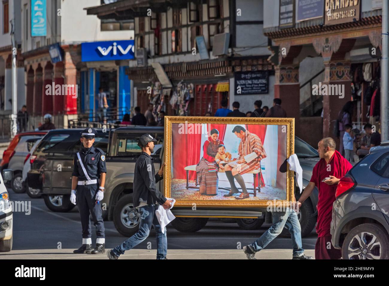 Des hommes portant une peinture de la famille du roi dans la rue Thimphu, Bhoutan Banque D'Images