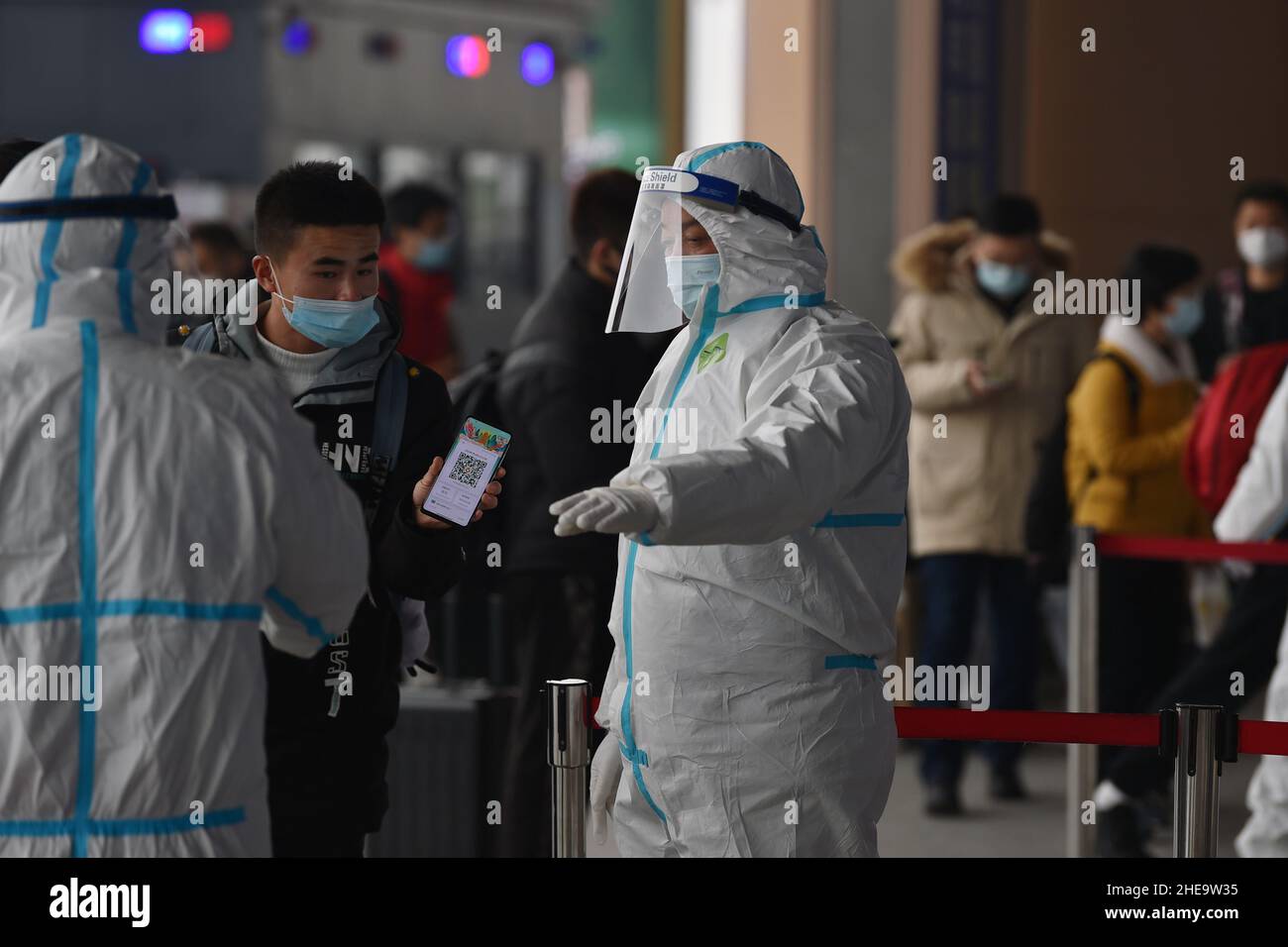 NANJING, CHINE - 10 JANVIER 2022 - les travailleurs de la prévention des épidémies vérifient les informations sanitaires des passagers un par un à l'entrée de Nanjing South Railw Banque D'Images