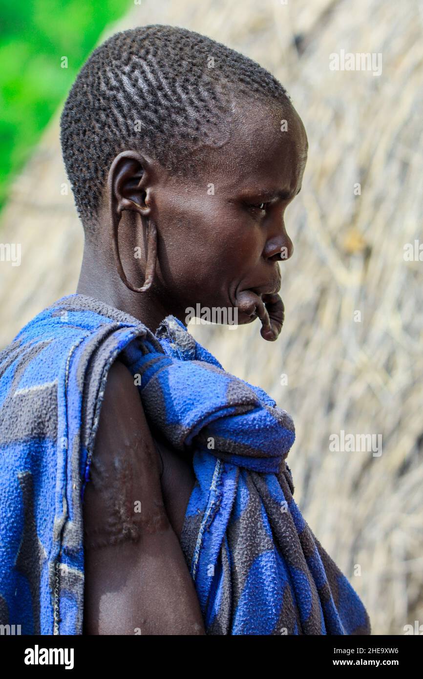 Omo River Valley, Ethiopie - 29 novembre 2020: Portrait d'une femme africaine avec de grands trous dans les oreilles avec les cheveux coupés dans le village de la tribu locale de Mursi Banque D'Images