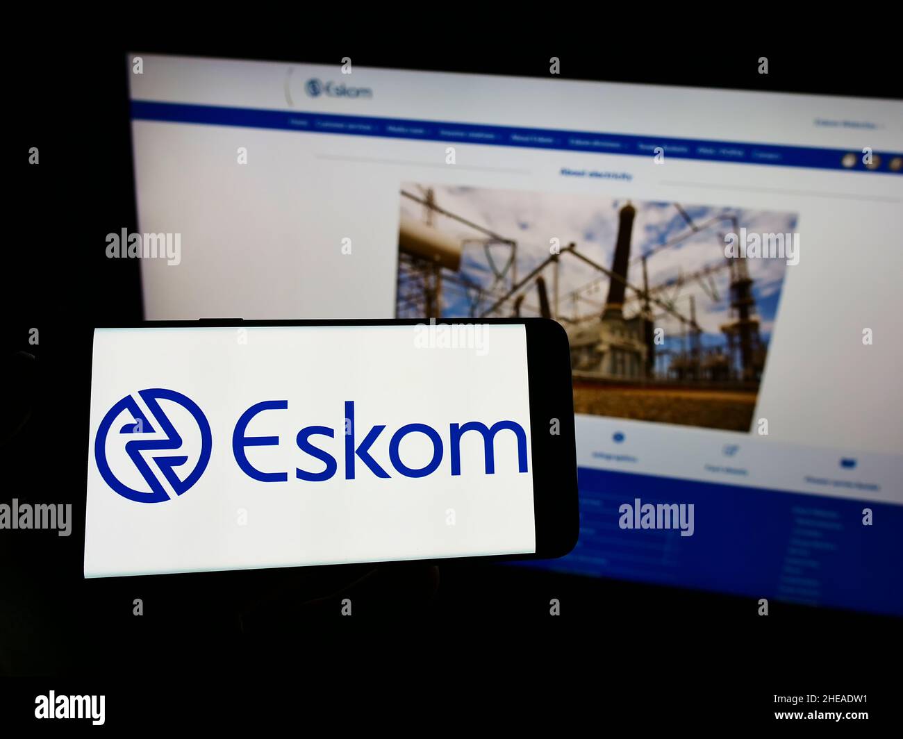 Personne tenant un smartphone avec le logo de la société de services publics Eskom Holdings SOC Ltd. À l'écran devant le site Web.Mise au point sur l'affichage du téléphone. Banque D'Images