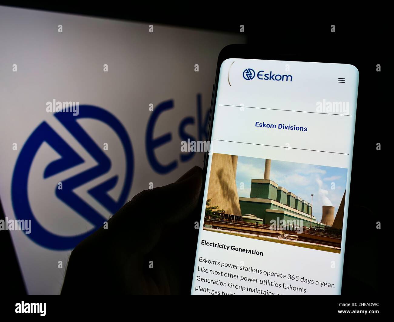 Personne tenant un téléphone portable avec la page Web de la société de services publics Eskom Holdings SOC Ltd. À l'écran devant le logo.Concentrez-vous sur le centre de l'écran du téléphone. Banque D'Images