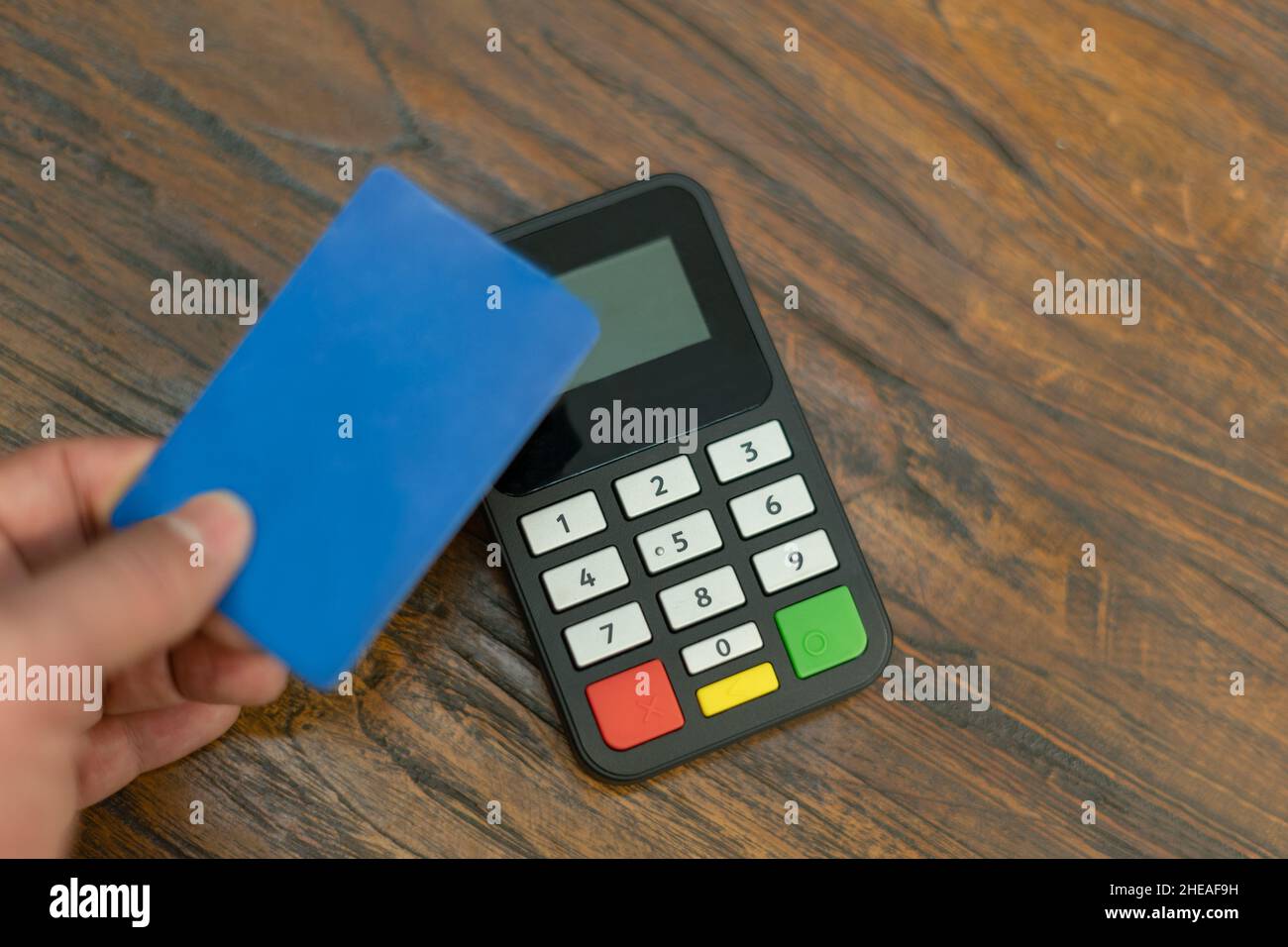 Main tenant la carte de crédit payant avec le terminal de paiement électronique dans le magasin Banque D'Images