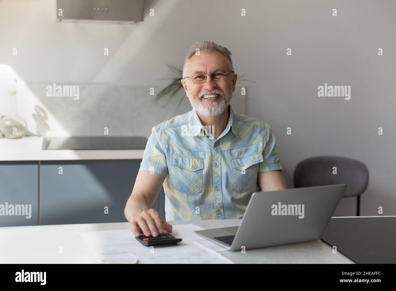 Portrait d'un heureux homme d'âge moyen de 60s ans gérant le budget. Banque D'Images