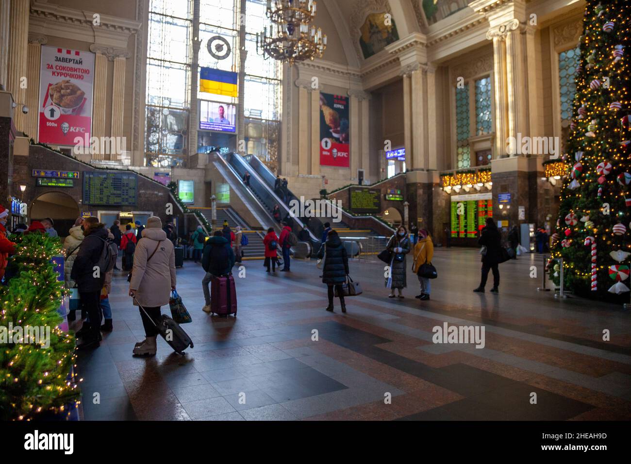 Ukraine, Kiev - 7 janvier 2022 : bâtiment de la gare à l'intérieur.Hall avec un arbre de noël, escalier roulant et personnes avec des valises voyagent et attendent leur train.Voyageurs à la gare Banque D'Images