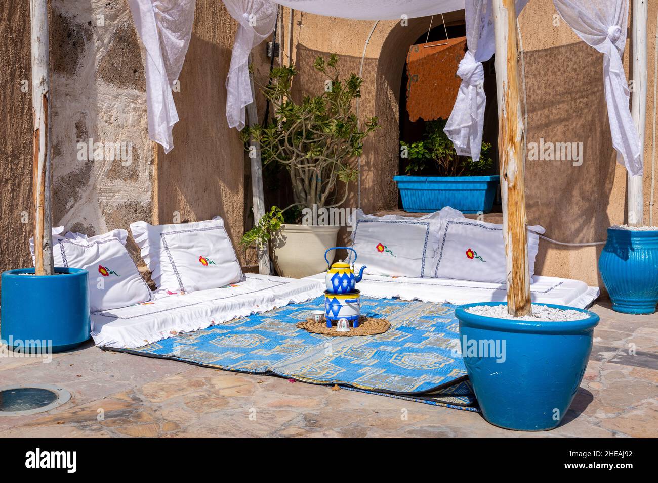 Arabic majlis, salon arabe traditionnel au sol avec coussins blancs, tapis bleu et théière, Old Dubai, Deira, eau. Banque D'Images