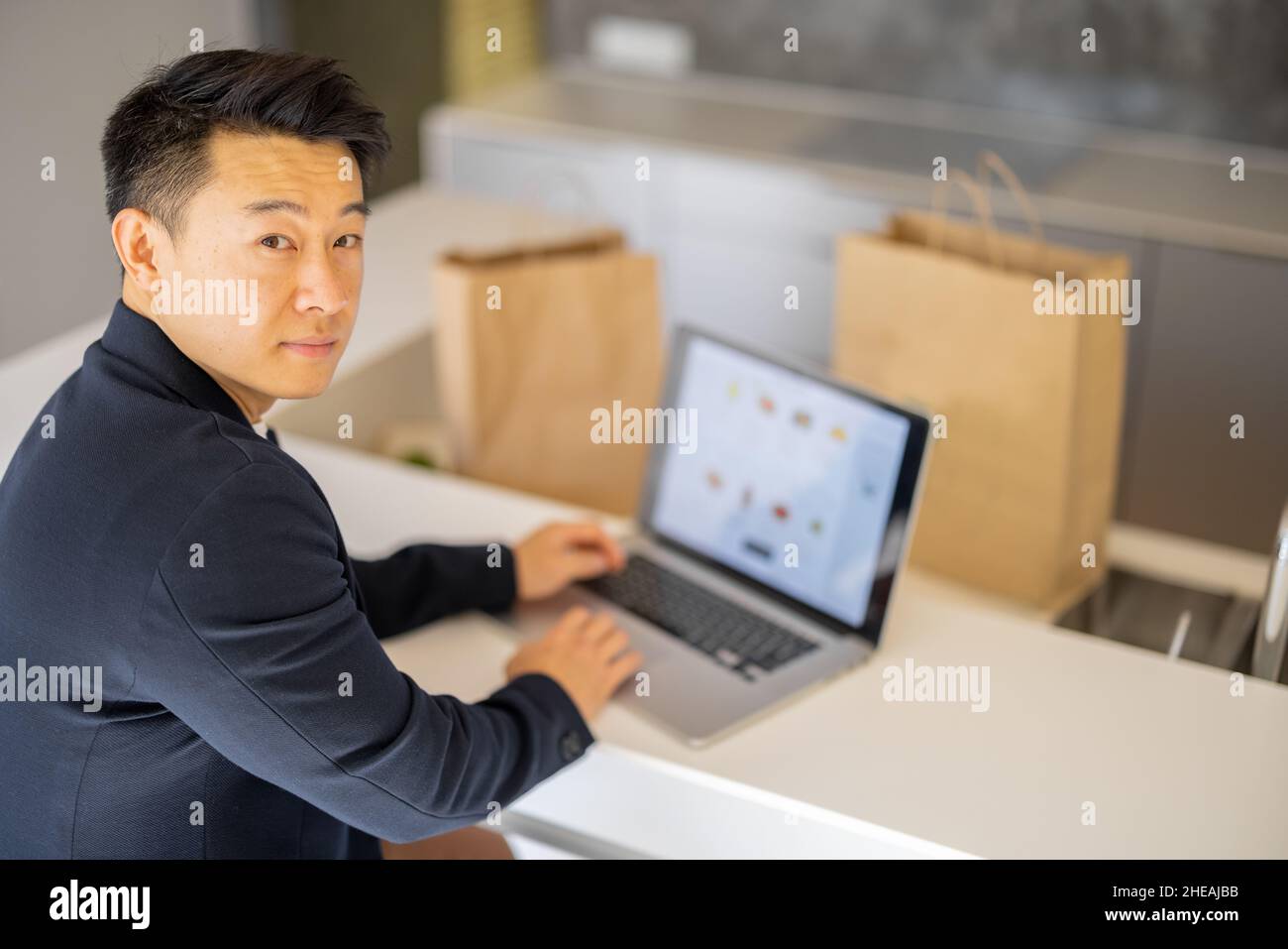 Homme choisissant des produits d'épicerie dans le magasin en ligne sur ordinateur portable Banque D'Images