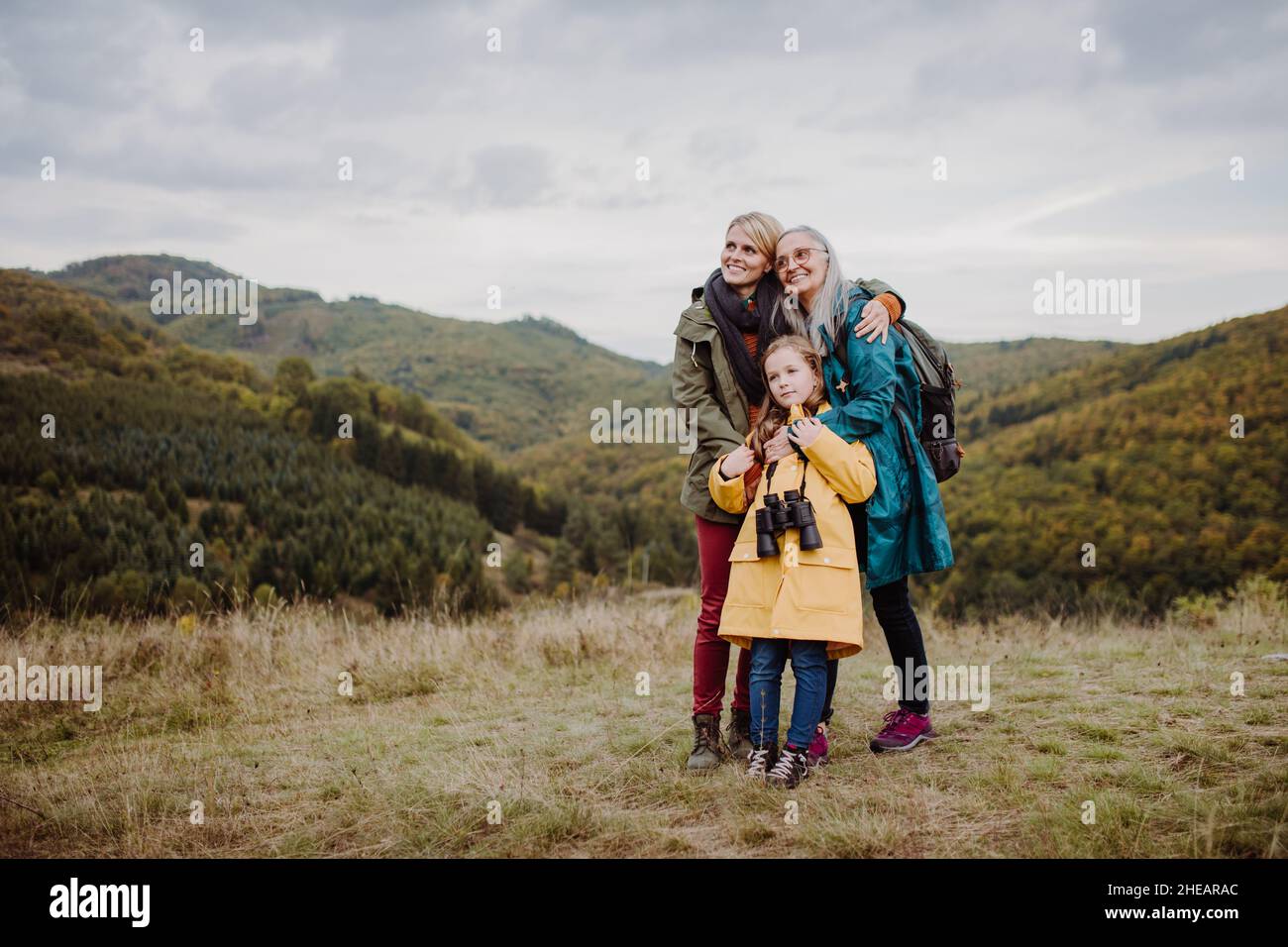Petite fille avec mère et grand-mère debout et lookiong en vue sur le sommet de la montagne. Banque D'Images
