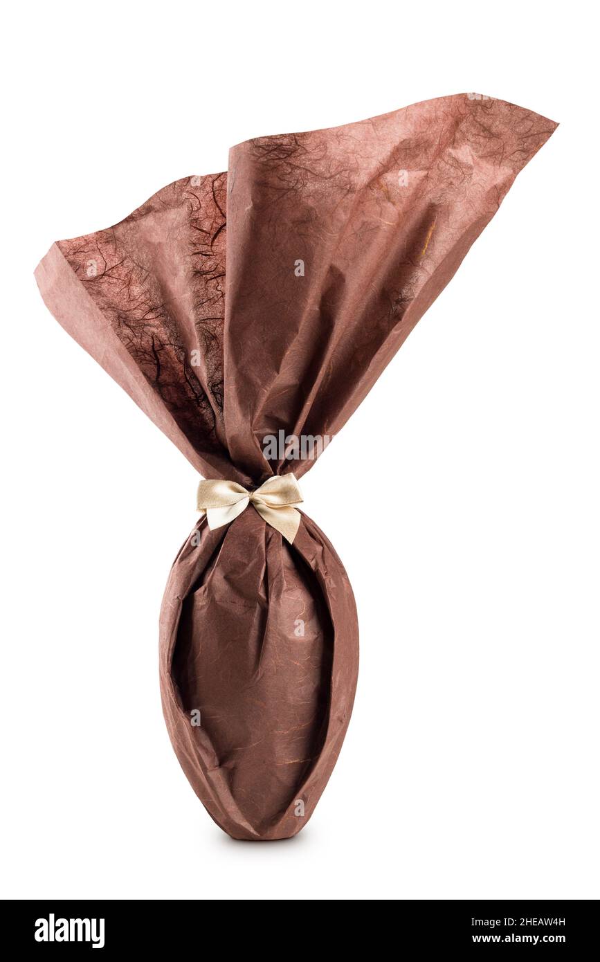 Œuf de pâques au chocolat emballé avec un élégant papier brun sur fond blanc Banque D'Images