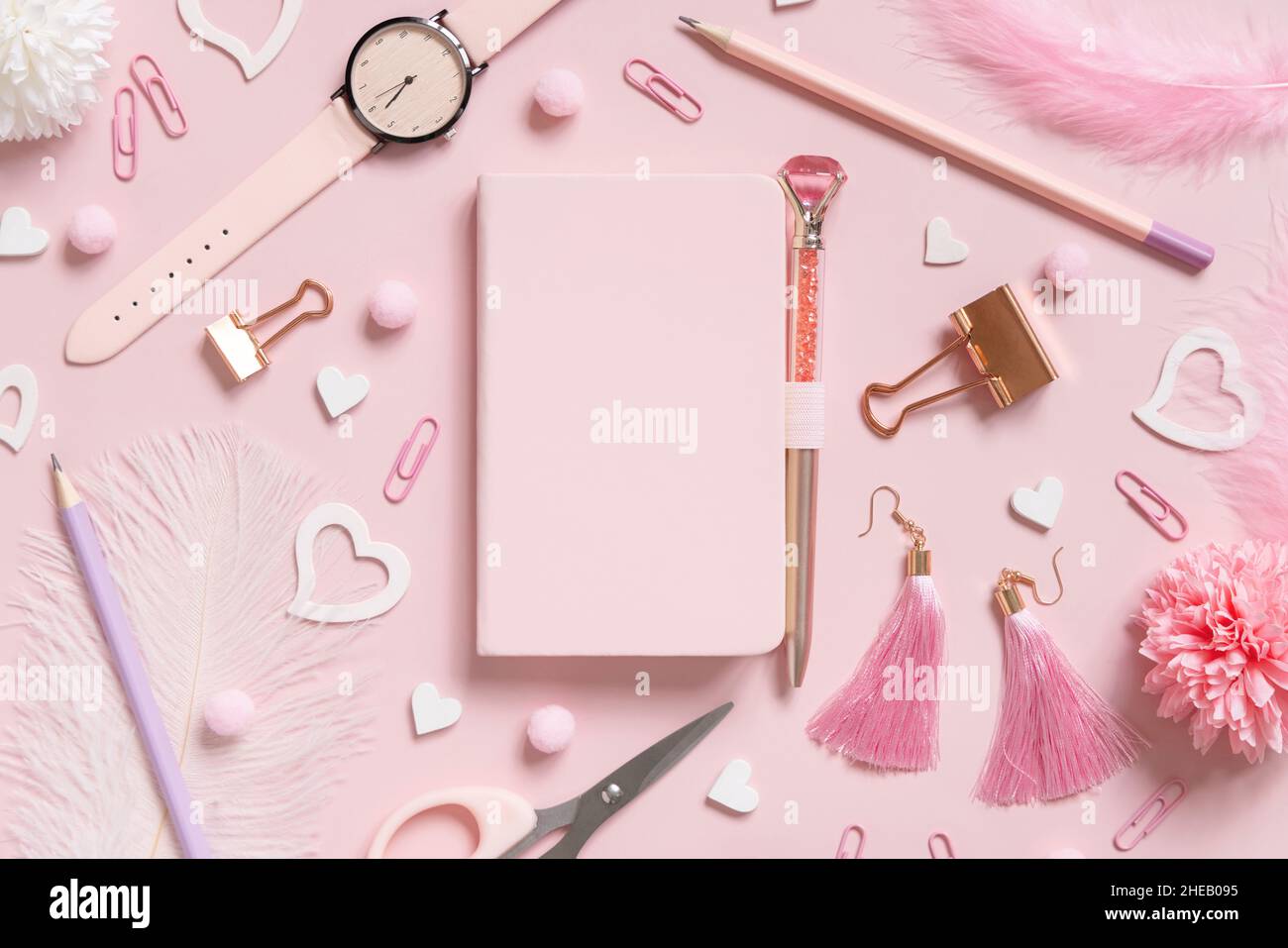 Cahier à couverture rigide, accessoires d'école rose et coeurs sur rose clair, vue de dessus, maquette de manuel.Gilly Workplace avec ordinateur portable, ciseaux, crayon, stylo, Banque D'Images