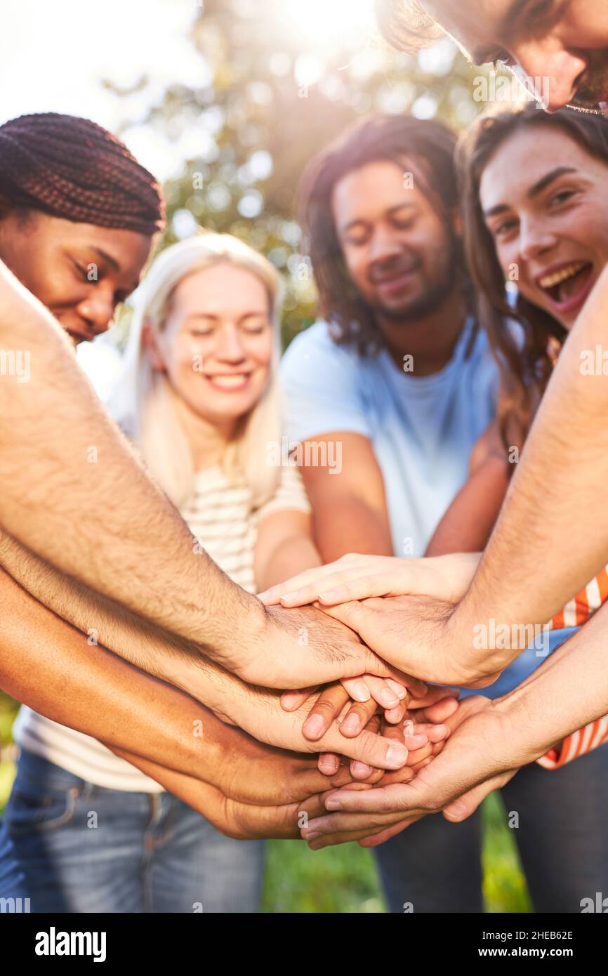 Un groupe d'amis qui se superpile les mains symbolisant le développement de la communauté et de l'équipe Banque D'Images