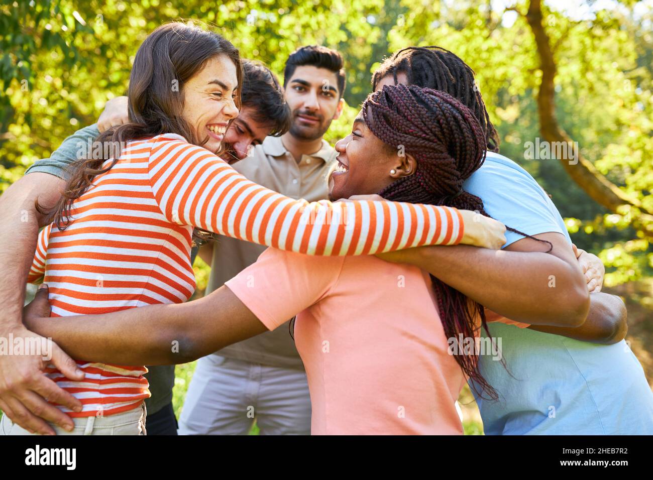 Groupe multiculturel de jeunes qui s'embrasent pour l'intégration et le renforcement d'équipe Banque D'Images