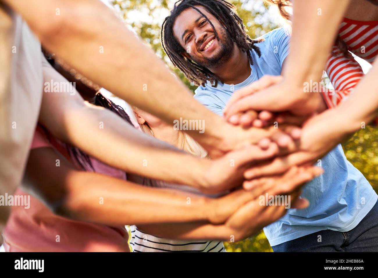 Un groupe multiculturel d'amis qui se superposez aux mains pour la diversité et le renforcement de l'équipe Banque D'Images