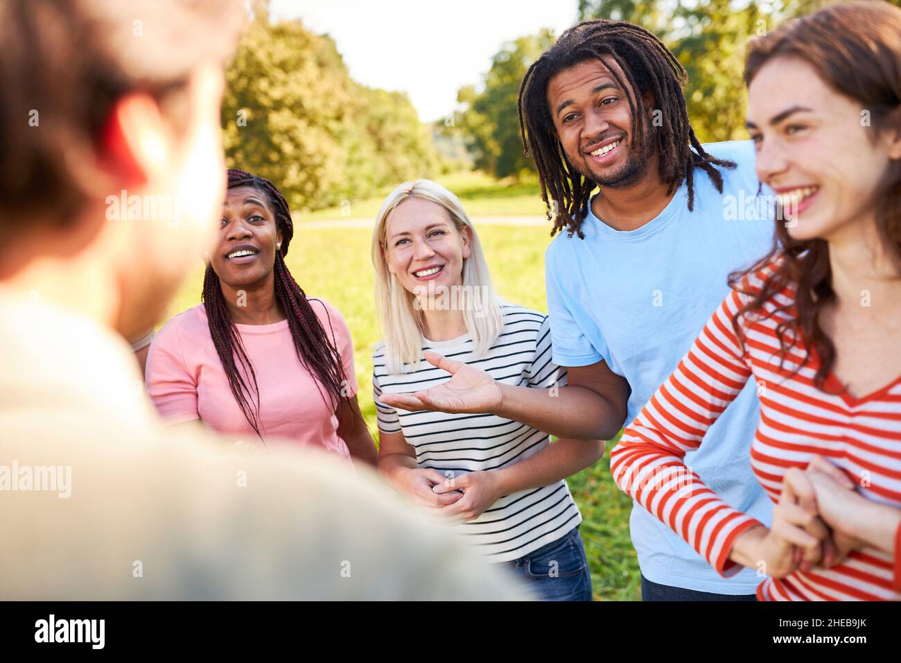 Divers groupes de jeunes comme amis et étudiants ayant de petites discussions dans le parc en été Banque D'Images