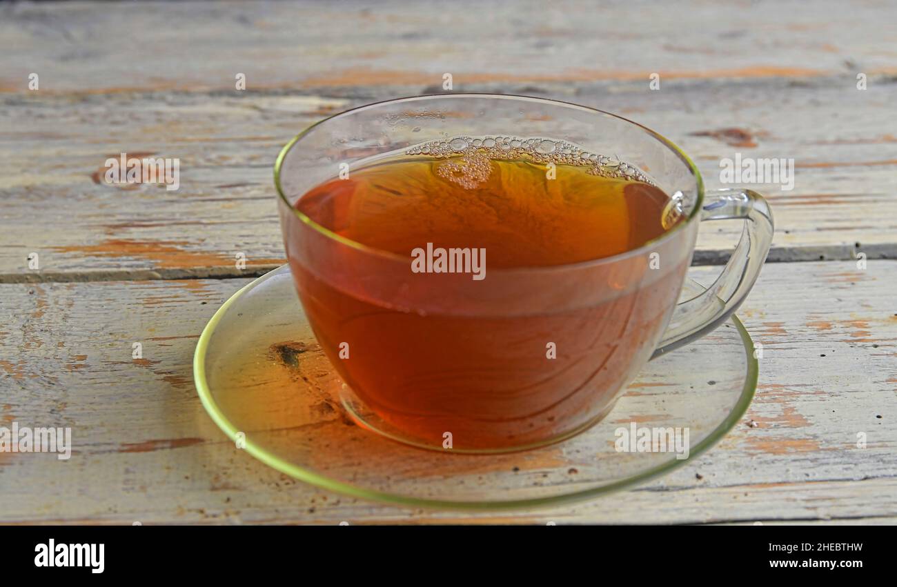 Délicieux thé noir dans une tasse transparente.Tasse de thé sur fond rustique en bois Banque D'Images
