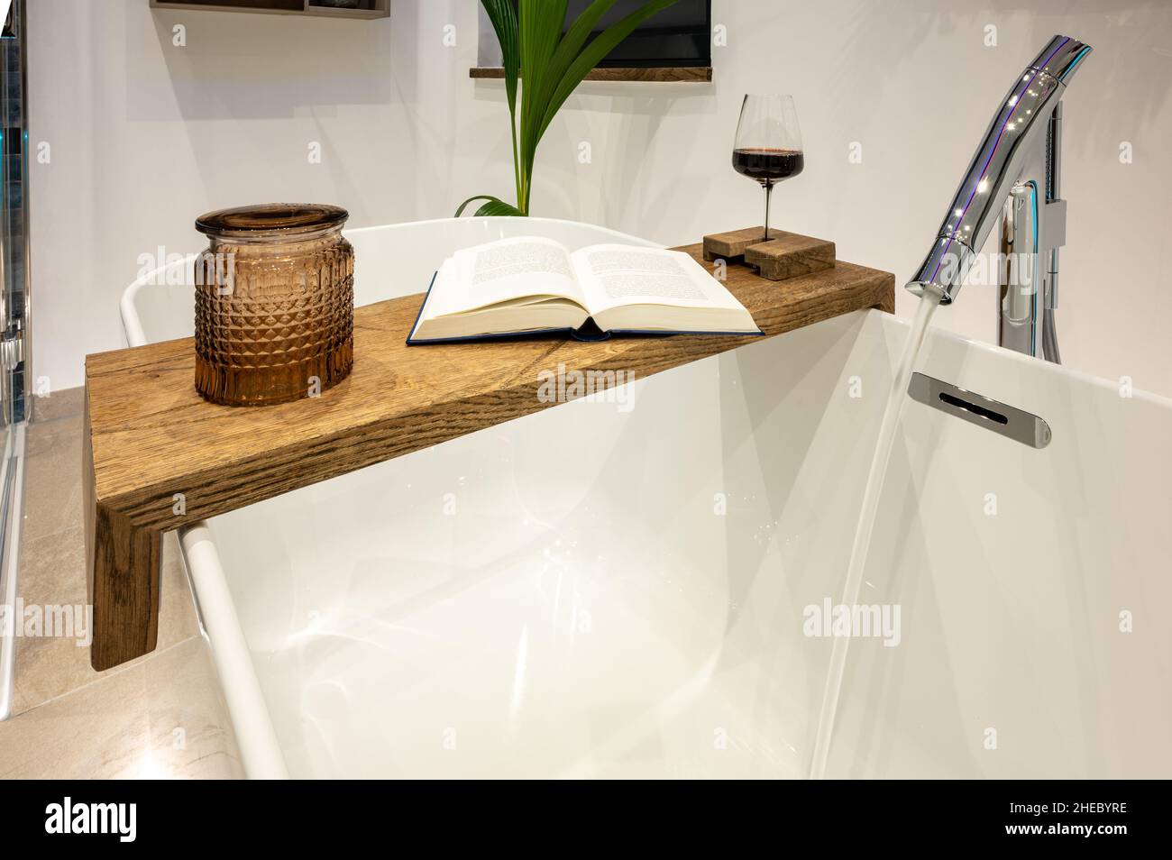 Étagère en bois sur une baignoire sur pied - faites tremper dans la  baignoire et détendez-vous avec un vin rouge et un livre Photo Stock - Alamy