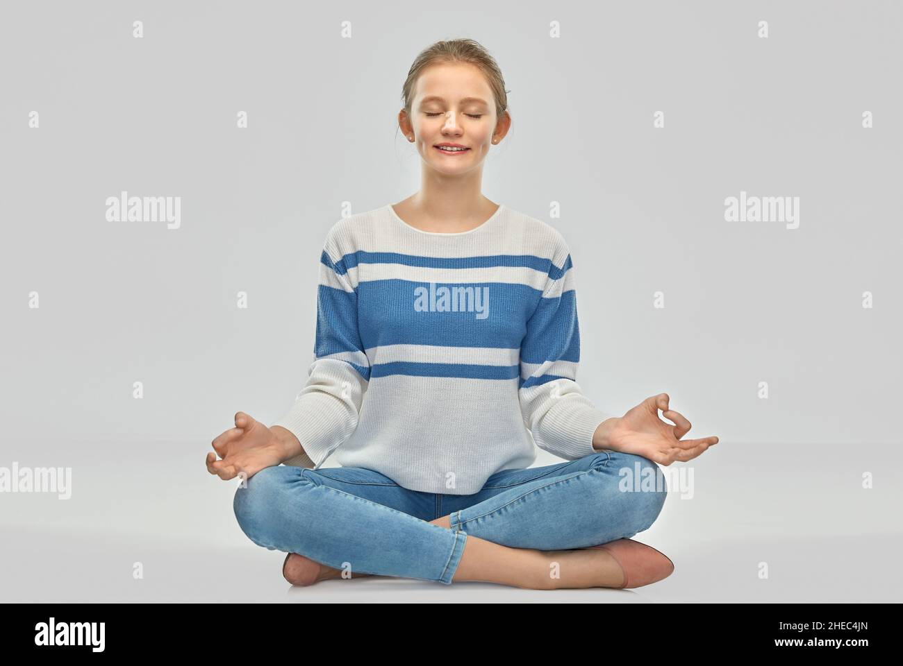 jeune fille souriante méditant dans la pose de lotus Banque D'Images