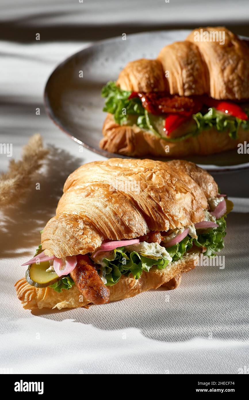Sandwich croissant - saucisse bavaroise, laitue et fromage à la  crème.Soleil aux ombres profondes Photo Stock - Alamy