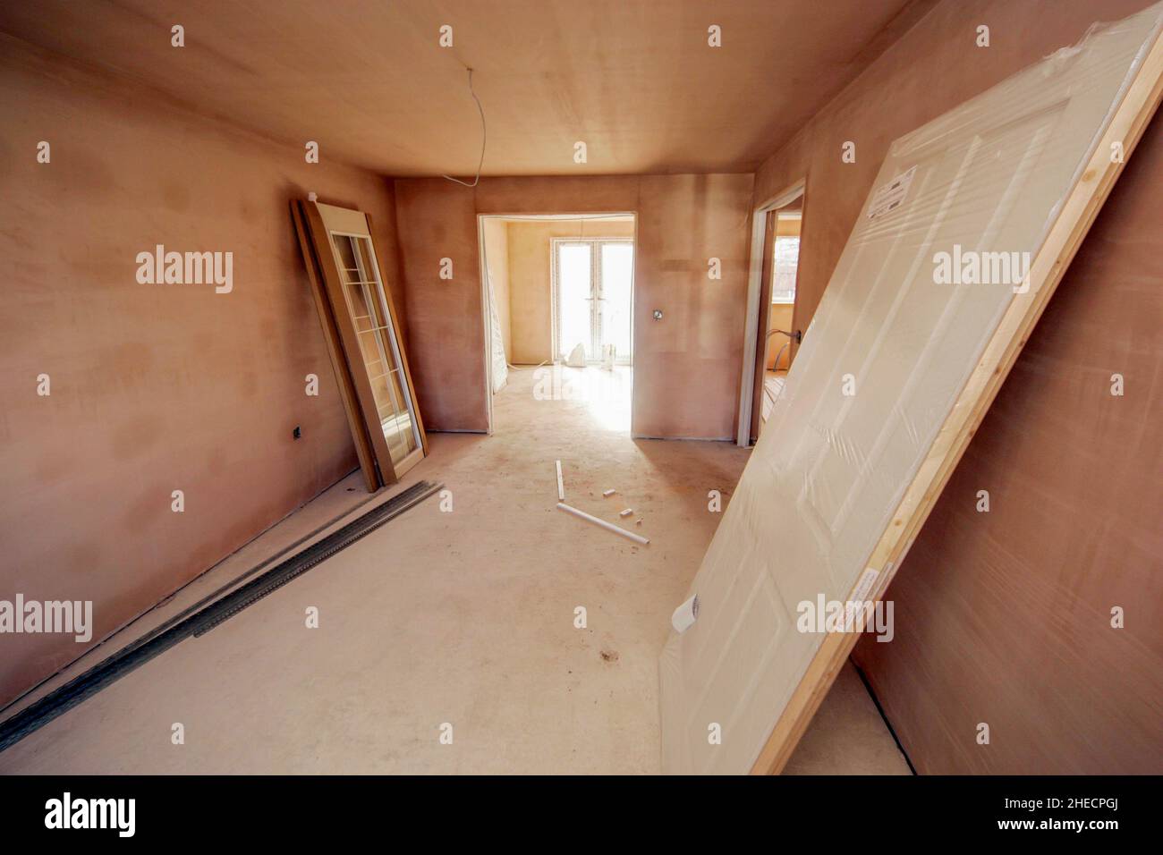 Intérieur fraîchement plâtré d'une maison moderne de construction nouvelle, portes prêtes à être installées, câblage incomplet, séchage Banque D'Images