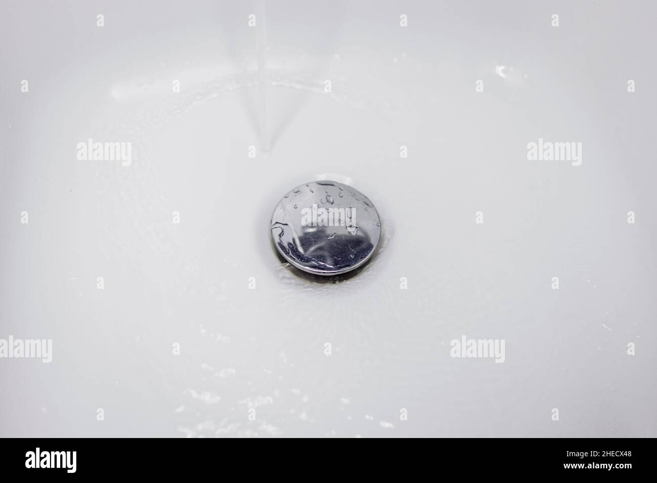 L'eau s'écoule dans le drain du lavabo Banque D'Images