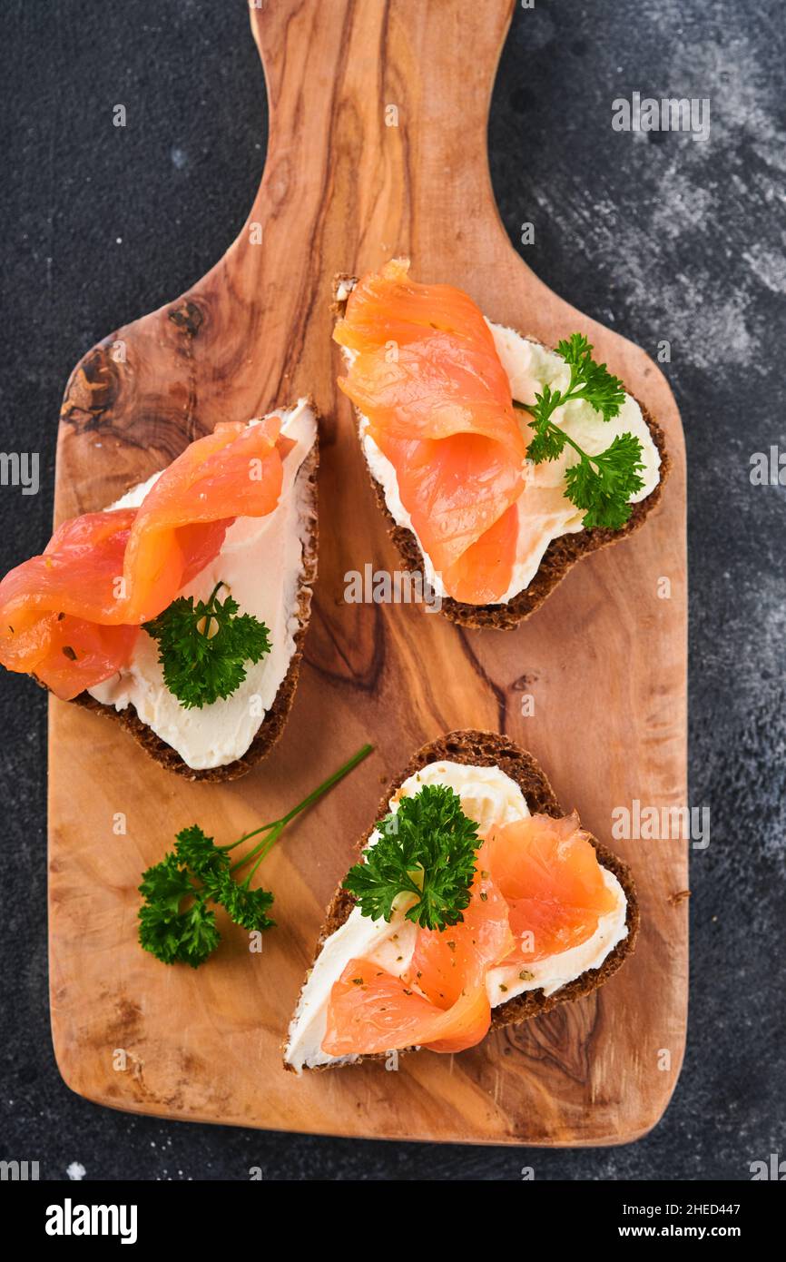 Mini sandwiches avec du saumon, du fromage caillé, du persil et du pain de seigle sous forme de coeurs.Saint-Valentin cuisine créative maison.J'adore le design du petit déjeuner.Séle Banque D'Images